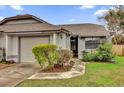 Front view of a tan house with a brown roof and landscaping at 2682 Orange Peel Ct, Orlando, FL 32806