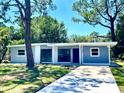 Newly renovated ranch home featuring a blue exterior and a long driveway at 308 Hope Cir, Orlando, FL 32811