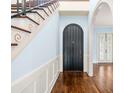 Elegant entryway with dark wood door, hardwood floors, and staircase at 907 Moss Ln, Winter Park, FL 32789