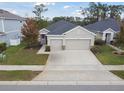 Lovely home with a two-car garage, manicured lawn, and tasteful landscaping, set against a backdrop of lush trees at 17860 Passionflower Cir, Clermont, FL 34714