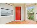 Inviting front porch with red door and tile flooring, offering a welcoming entrance to the residence at 3032 Parkway Blvd # 302, Kissimmee, FL 34747