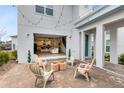 Relaxing patio with string lights, comfortable seating, and view into the home at 13104 Markowitz Aly, Orlando, FL 32827