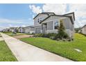 Landscaped home exterior features lush lawn, sidewalk, and a welcoming facade at 2949 Wild Olive Dr, St Cloud, FL 34772