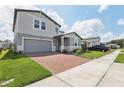Attractive home with well-kept lawn, brick driveway, and two-car garage at 2949 Wild Olive Dr, St Cloud, FL 34772
