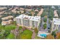 Aerial view of waterfront condominium featuring a pool, parking, and verdant landscape at 6336 Buford St # 705, Orlando, FL 32835