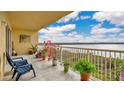 Lovely balcony with a serene lake view, plants, and furniture for relaxation at 6336 Buford St # 705, Orlando, FL 32835
