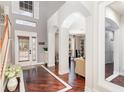 Elegant foyer featuring dark wood floors with bright trim, arched entryways, and a grand two-story entrance at 9168 Lake Avon Dr, Orlando, FL 32829