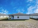 View of the back of the house showing the covered patio and yard at 1123 Union Ave, Mascotte, FL 34753