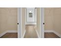 Hallway showing access to a bright bathroom with a glass-enclosed shower at 139 Malauka Pass, Ocklawaha, FL 32179