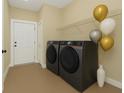 Well-equipped laundry room with modern washer and dryer, storage shelving and a neutral color scheme at 139 Malauka Pass, Ocklawaha, FL 32179