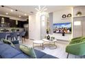 Stylishly furnished living room with modern lighting, sleek furniture, and open-concept design at 4294 Lana Ave, Davenport, FL 33897