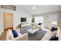 Bright living room with vaulted ceiling, plank flooring, and stylish white and navy furniture at 441 Danube Dr, Kissimmee, FL 34759