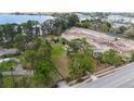 Aerial view of the property with nearby lake, surrounding trees, and adjacent construction site at 11326 Westwood Blvd, Orlando, FL 32821