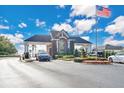 Inviting community entrance with manicured landscaping and American flag waving at 13256 Whisper Bay Dr, Clermont, FL 34711