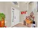 Bright foyer featuring a decorative table, Santa hats, and a tiled floor at 13256 Whisper Bay Dr, Clermont, FL 34711