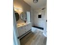 Contemporary bathroom featuring dual sinks, modern lighting, and a stylish walk-in shower with updated finishes at 15613 Greater Groves Blvd, Clermont, FL 34714
