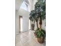 Bright foyer featuring tile flooring, a decorative palm, and a soaring window above the front door at 1907 Lakeview Way, Kissimmee, FL 34759