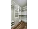 This walk-in closet features custom white shelving, drawers, and clothing rods for optimal storage organization at 350 Marion Oaks Pass, Ocala, FL 34473
