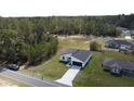 Aerial view showcasing the home's location, surrounding forest, driveway and neighboring houses at 559 Marion Oaks Blvd, Ocala, FL 34473