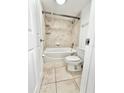 Bright bathroom featuring a shower and bathtub combo with tile surround, a toilet, and tiled flooring at 1918 Conway Rd # 3, Orlando, FL 32812