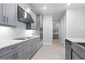 Stylish kitchen boasts gray cabinets, stainless steel hood, and sleek cooktop at 2990 Arranmore Dr, Ormond Beach, FL 32174