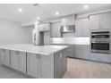 Modern kitchen featuring gray cabinets, stainless steel appliances, and a center island at 2990 Arranmore Dr, Ormond Beach, FL 32174