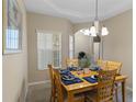 Light-filled dining room with a wood table, six chairs, and a stylish chandelier at 401 Montara Dr, Davenport, FL 33897