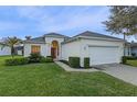 House exterior showcasing a two-car garage, manicured lawn, and inviting front porch at 401 Montara Dr, Davenport, FL 33897