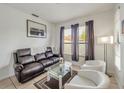 Living room with leather couch, glass coffee table, and two armchairs at 9564 Venezia Plantation Dr, Orlando, FL 32829