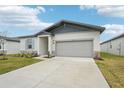 New construction home with gray siding, light stone accents, and a two-car garage at 2121 Rosewood Dr, Bartow, FL 33830