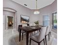 Elegant dining room with chandelier lighting, large window, and views to living areas at 571 Masalo Pl, Lake Mary, FL 32746