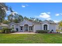 Charming single-story home featuring a lush lawn, brick pathway, and mature landscaping at 571 Masalo Pl, Lake Mary, FL 32746