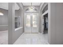 Bright foyer showcasing marble floors, chandelier, and an arched doorway at 571 Masalo Pl, Lake Mary, FL 32746