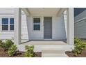 Inviting front porch with gray door and white pillars, framed by manicured landscaping at 2378 Broadbrook Dr, St Cloud, FL 34771
