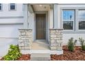 Inviting home entrance with stone pillar accents, a dark front door and coordinated landscaping at 339 Conway Ave, St Cloud, FL 34771
