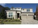 Two-story home features a two-car garage, manicured front lawn, and beautiful brick driveway at 9271 Patrimonio Loop, Windermere, FL 34786