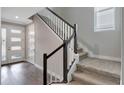 Bright foyer with staircase, dark wood floors, and natural light from a side window at 2221 Avian Loop, Kissimmee, FL 34741