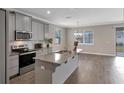 Open kitchen with island, granite countertops, stainless appliances, and views of the backyard at 2221 Avian Loop, Kissimmee, FL 34741