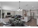 Open-concept living and dining area with hardwood floors and stainless steel appliances at 2221 Avian Loop, Kissimmee, FL 34741