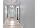 Bright foyer featuring neutral tile flooring and a decorative front door with transom window at 4731 Summerbridge Cir, Leesburg, FL 34748