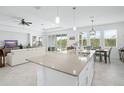 Modern kitchen with an island bar and sink, open to the living room, and a dining space with outdoor view at 6115 Claystone Way, Mount Dora, FL 32757