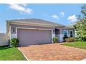 Two-car garage and a well-manicured lawn at 9355 Westmorely St, Groveland, FL 34736
