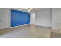 Spacious living room with blue accent wall and tile floor at 9355 Westmorely St, Groveland, FL 34736