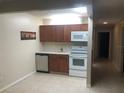 Efficient kitchen features white appliances and ample wood cabinetry at 134 W America St # 29, Orlando, FL 32801