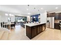 Open concept kitchen with island and view into living area at 8851 Geneve Ct, Kissimmee, FL 34747