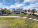 Well-maintained backyard featuring a spacious lawn and a patio with outdoor seating and a manicured landscape at 15155 Mayberry Dr, Winter Garden, FL 34787