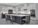 Modern kitchen features a large center island with seating, white cabinets, and stainless steel appliances at 15155 Mayberry Dr, Winter Garden, FL 34787