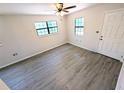 Unfurnished living room showcasing wood floors, neutral walls, bright windows, and ample space at 19942 Se 155Th Pl, Umatilla, FL 32784