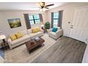 Bright living room featuring wood floors, neutral walls, and updated furnishings in a staged setting at 19942 Se 155Th Pl, Umatilla, FL 32784