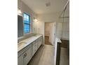 Double vanity bathroom with walk-in shower and closet at 3185 Songbird Cir, Harmony, FL 34773